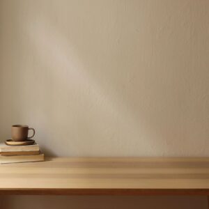 Styled product photo of a ceramic mug on a wooden table with warm cream background and copy space for a customizable name or message area (soft pink/blue accents).