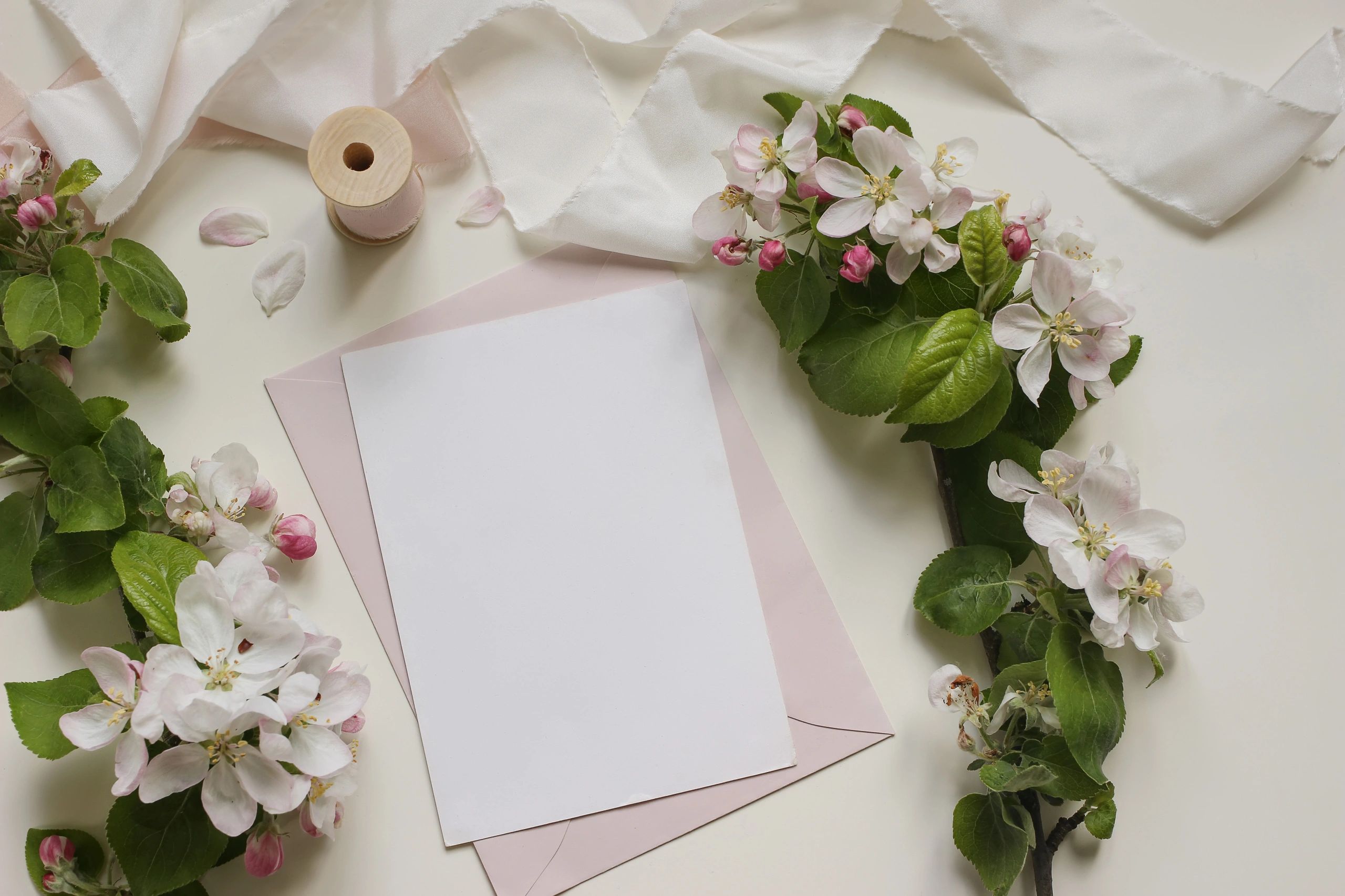 Blank greeting card with pink envelope and spring blossoms